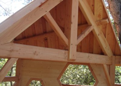 Zoom sur la charpente d'une cabane perchée dans les arbres